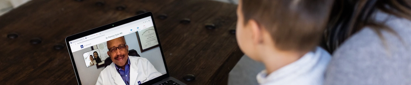 Woman with young kid in video call on laptop