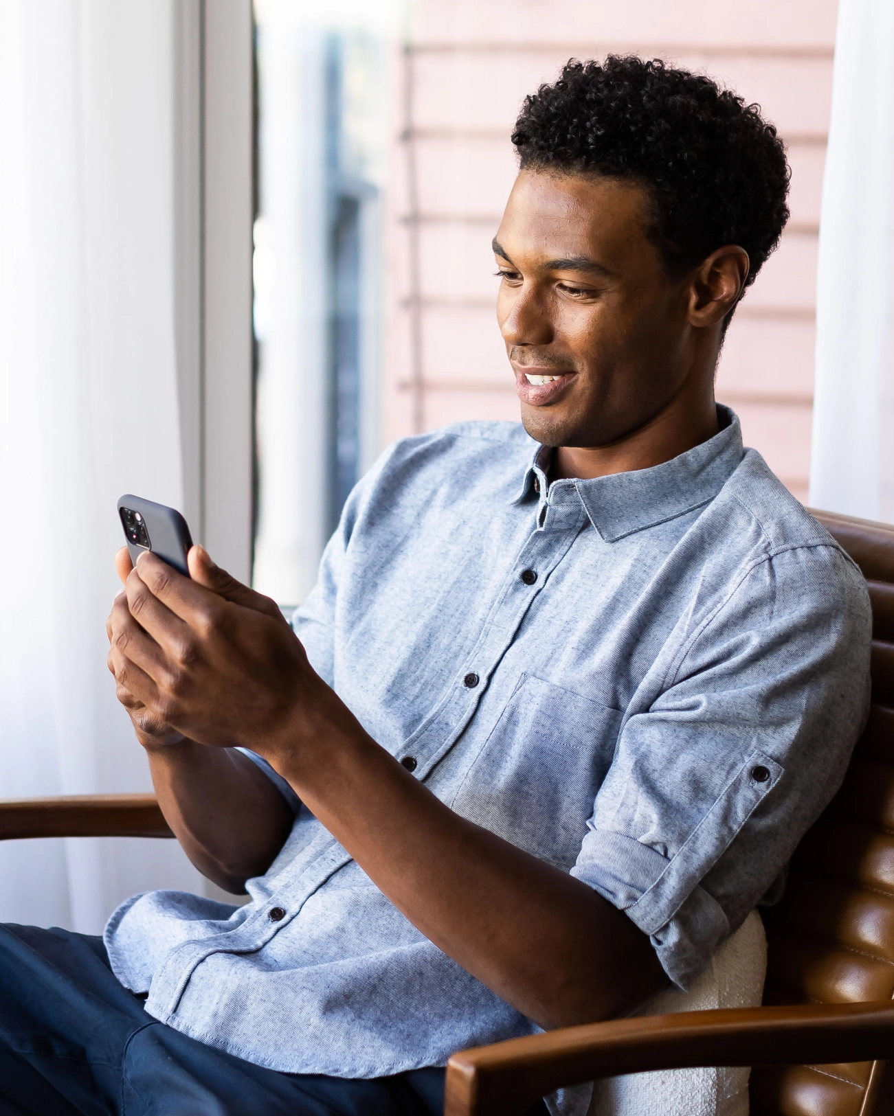 young man smiling and looking at his phone