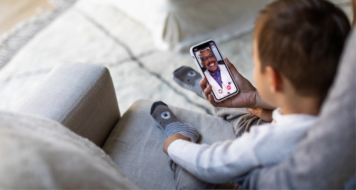 Mom with child talking to a doctor on Patient To Prescription app.