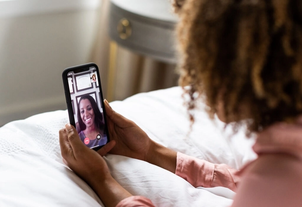 woman on bed using Patient To Prescription telehealth app