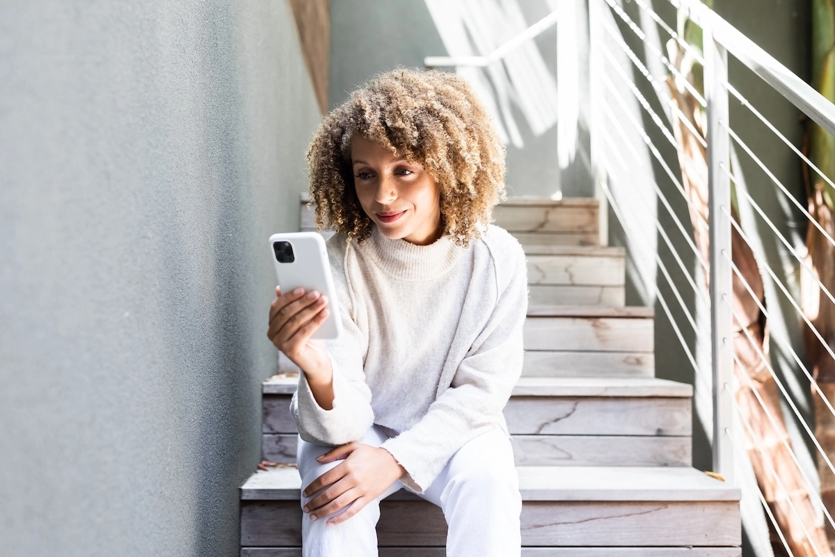 woman using her mobile device to have an online telehealth visit with a doctor
