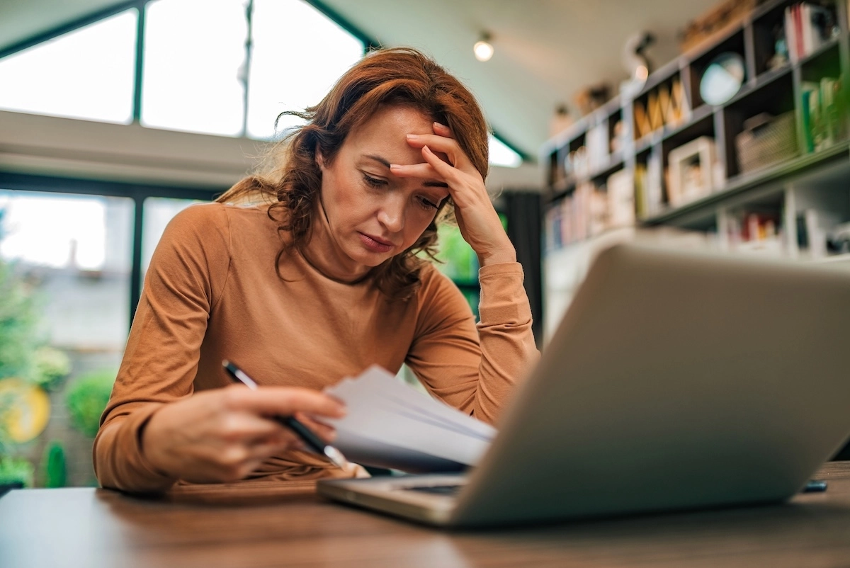 stressed woman holding her head struggling with a migraine